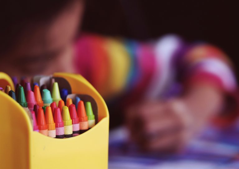 back to school image of crayons and child colouring